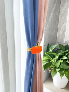 Orange pumpkin curtain tieback with elastic metal band for home window decoration design.