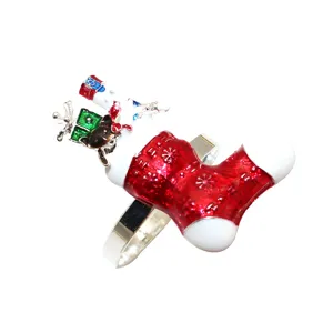 Christmas stocking napkin ring detail, silver metal band with red enamel and gift box decor.