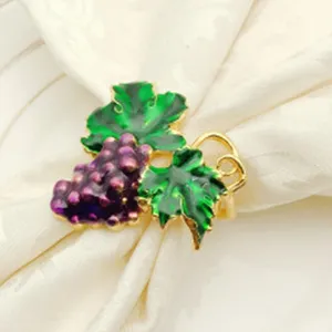 Dettaglio portatovagliolo uva e foglia, accessorio da tavola in metallo smaltato per feste.