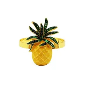 Primo piano dettagliato di un portatovagliolo ad ananas placcato in oro con foglie di cristallo verde.