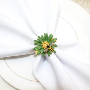 Dettaglio dello squisito portatovagliolo con margherita verde per decorazione tavola.