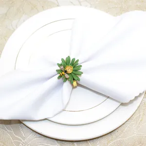 Primo piano di anello portatovagliolo margherita verde con ape in strass su tovagliolo bianco