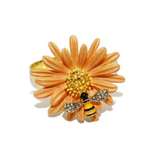 Dettaglio in primo piano dell'anello portatovagliolo margherita arancione con ape in strass lucida.