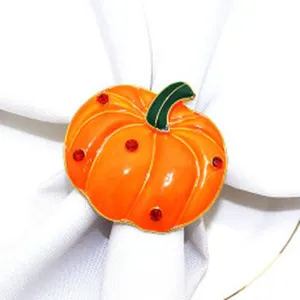 Close-up detail of the orange pumpkin napkin ring with green stem and red rhinestones.