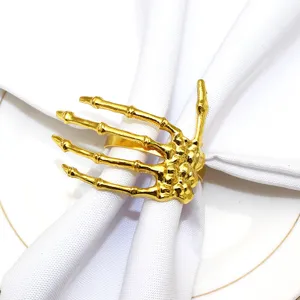 Gold skeleton hand napkin ring for Halloween table decor, gothic dinner party accessory.