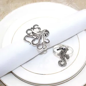 Detailed view of vintage silver metal octopus and seahorse napkin rings for table decor.