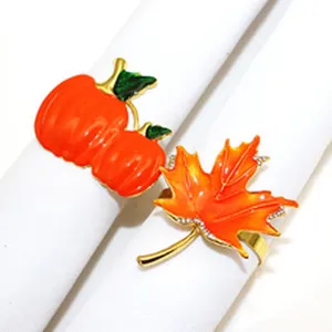 Detail view of the autumn pumpkin and maple leaf napkin ring featuring gold alloy and enamel.