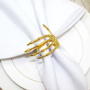 Gold skeleton hand napkin ring close-up, perfect for Halloween table decor and party settings.
