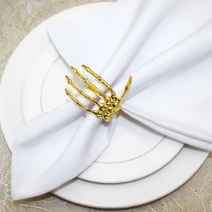 Gold skeleton hand napkin ring detail view, spooky Halloween table decor accessory close up.