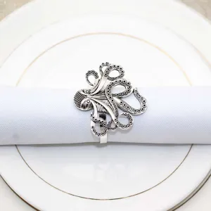 Vintage silver metal octopus napkin ring detail for rustic dining table decor and party.