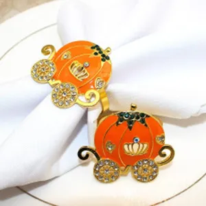 Detailed close-up of decorative orange pumpkin carriage napkin rings with rhinestones.