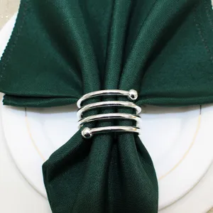 Silver metal spring napkin ring detail with double beads, elegant table decor close-up view.