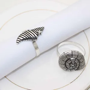 Close-up detail of vintage metal shell napkin rings, elegant table decor setup for dining.