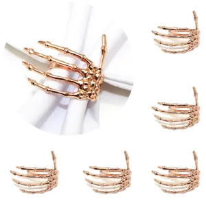 Rose gold skeleton hand napkin ring detail view, spooky Halloween table decor accessory.