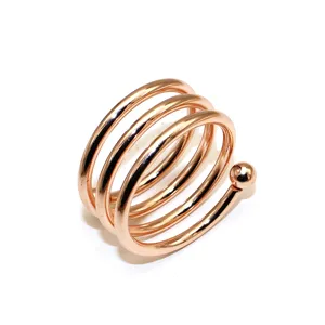 Rose gold metal spiral napkin ring detail shot, elegant table decor and hotel tableware accessory.