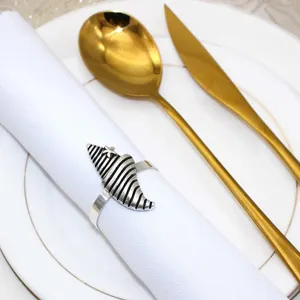 Detail view of a vintage seashell napkin ring, elegant metallic finish for table decor.