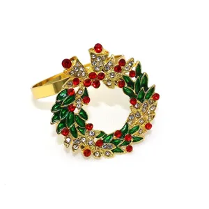Christmas wreath napkin ring with red rhinestones, green enamel leaves, and metallic gold finish.