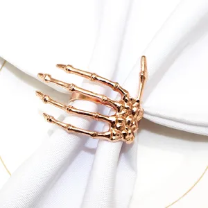 Rose gold skeleton hand napkin ring detail close up view for Halloween table decor.