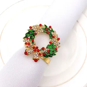 Close-up detail of Christmas wreath napkin ring with red rhinestones and gold alloy design.