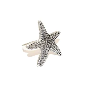 Starfish napkin ring detail shot, vintage silver metal texture, elegant table decor piece.