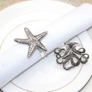 Close up of vintage silver metal napkin rings featuring marine life starfish and octopus designs.