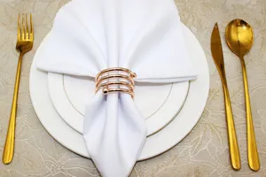 Elegant rose gold spring napkin ring detail, metal napkin holder for dining table decor.