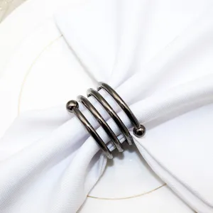 Metal spring napkin ring detail view, elegant black metal tableware holder for decor.