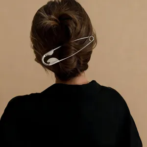 Gros plan détaillé d'une grande pince à cheveux en métal en forme d'épingle sur chignon.