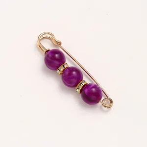 Gold-toned safety pin brooch featuring purple marbled beads and rhinestones for waist adjustment.
