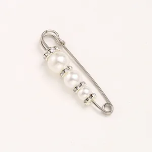 Pearl rhinestone safety pin detail close-up, elegant decorative brooch for waist fit.