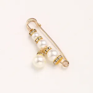 Gold pearl rhinestone safety pin brooch, waist tightening clothing detail view.