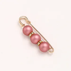 Gold tone safety pin brooch with pink matte pearls and crystal rhinestones for clothing waist.