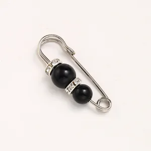 Detail shot of decorative safety pin with black beads and rhinestones for waist adjustment