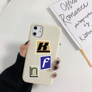 Gros plan détaillé d'une coque de téléphone portable beige décorée de stickers lettres.