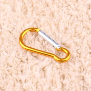 Gold aluminum gourd carabiner detail, lightweight metal snap hook for outdoor use and keys.