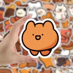 Cute orange cartoon bear sticker held by hand, perfect for decorating phone cases and laptops.