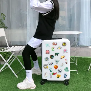 Detailed view of various aesthetic waterproof decorative stickers displayed on a white suitcase.