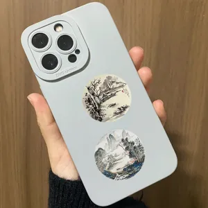 Close-up detail of traditional Chinese ink landscape painting round stickers on phone case.