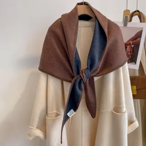 Detailed view of the stylish two-toned triangular shawl draped elegantly with cozy knit fabric.