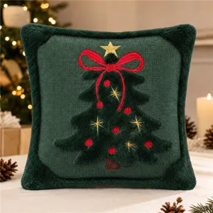 Primo piano della federa per cuscino in peluche ricamata con albero di Natale decorativo.