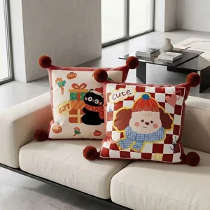 Festive red sofa throw pillow with cute cartoon print and corner pom-poms for home decor.