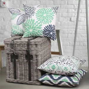 Detailed view of botanical and geometric throw pillow covers showcasing vibrant green and blue prints.