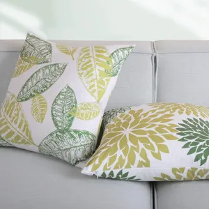 Close-up detail of abstract leaf pattern throw pillow cover, showing soft fabric texture on sofa.