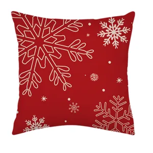 Primer plano detallado de la funda de cojín navideña roja con patrones de copos de nieve blancos.