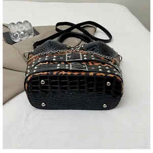 Y2K punk style handbag detail, black embossed crocodile texture with leopard print and metal studs.