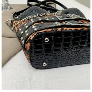 Punk Y2K style shoulder bag featuring black crocodile pattern, leopard print and metal studs.