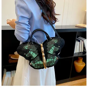 Details of the unique butterfly-shaped shoulder bag featuring striking green and black wing patterns.
