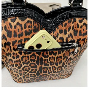 Vintage leopard print handbag detail showing front zipper pocket and unique heart-shaped top trim design.
