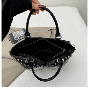 Black croc-embossed Y2K studded handbag detail showing spacious interior compartments and chain.