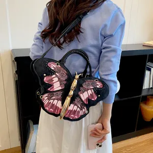 Unique butterfly shape crossbody bag with pink wing pattern and golden metal body for women.